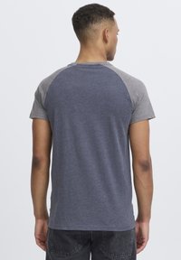 Short-sleeve T-shirt featuring a dark blue body with gray raglan sleeves, made from a soft, textured fabric, suitable for casual wear.