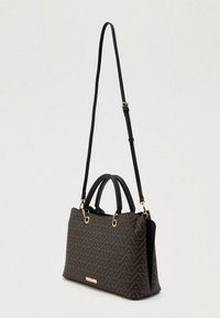 Czarna i brązowa torba o geometrycznym wzorze z podwójnymi uchwytami u góry i odczepianym paskiem na ramię. Złote akcenty hardware świetnie się prezentują.