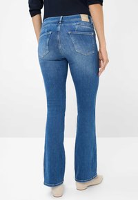 Blauwe spijkerbroek met een flare, mid-rise taille, vijf zakken en een leren label op de achterzijde van de tailleband. Glad textuur, klassiek pasvorm.