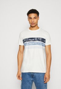 Weißes Baumwoll-T-Shirt mit horizontalen blauen und marineblauen Streifen über der Brust, Rundhalsausschnitt und kurzen Ärmeln. Freizeitliche Passform.