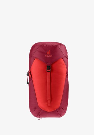 Mochila roja y marrón con una parte superior redondeada, correa ajustable y logo. Presenta una textura suave y un diseño elegante y aerodinámico.