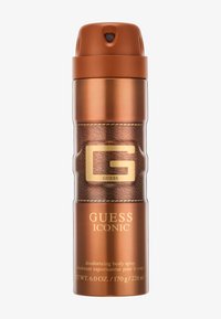 Vaporisateur corporel désodorisant de couleur bronze avec une étiquette marron texturée, des accents dorés et "GUESS ICONIC" affiché de manière proéminente.