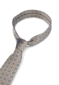 Cravate en soie ornée d'un motif géométrique de cercles bleus et dorés sur un fond gris clair. Extrémités effilées avec un design noué.