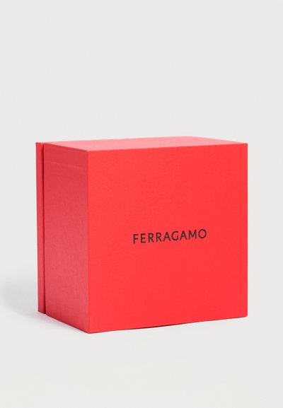 Boîte rectangulaire rouge Ferragamo avec logo noir centré sur un fond gris clair uni.