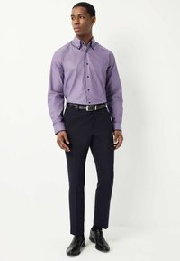 Paarse gestreepte overhemd met knopen, gecombineerd met donkere broeken en zwarte schoenen. Heeft contrasterende knopen en een slim fit.