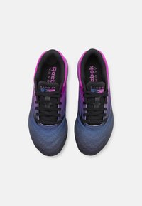 A Reebok Nano XV cipők lila és kék közötti átmenetes dizájnnal rendelkeznek, texturált hálós felső résszel és fekete fűzőkkel.