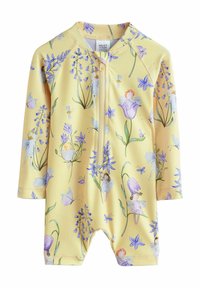 Napfény sárga rash guard hosszú ujjakkal, elöl cipzáros záródással és virágmintával, amely lepkéket és tündéreket ábrázol. Simogatós, könnyű anyagból készült.