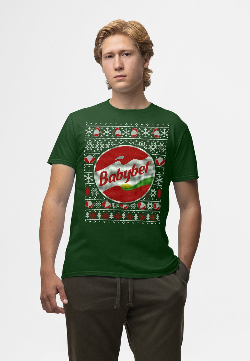 Zelené bavlněné tričko s velkým červeným logem Babybel, obklopené vánočními ozdobami v bílé, červené a zelené barvě.