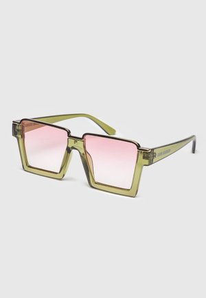 Sonnenbrille mit quadratischem Rahmen, durchscheinenden olivgrünen Bügeln und pinkfarbigen Verlaufsgläsern vor hellem Hintergrund.