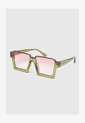 Lunettes de soleil à monture carrée avec des branches vert olive translucides et des verres dégradés roses sur un fond clair.