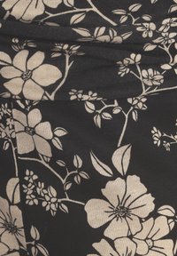 Zwarte stof met een wit bloemenpatroon, met grote bloesems en ingewikkelde bladeren. De textuur lijkt glad met een subtiele glans.