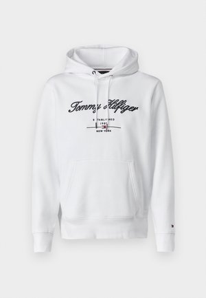 Fehér kapucnis pulóver, puha anyagból készült, húzózsinórral, elülső zsebből és hímzett logóból áll, amelyen a sötétkék "Tommy Hilfiger" felirat található.
