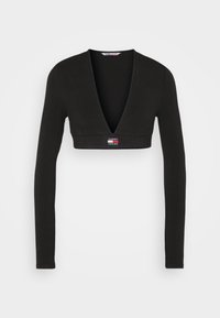 Černý zkrácený top s dlouhým rukávem a hlubokým výstřihem do V, vyrobený z hladkého materiálu, s malým logem Tommy Jeans na lemu.