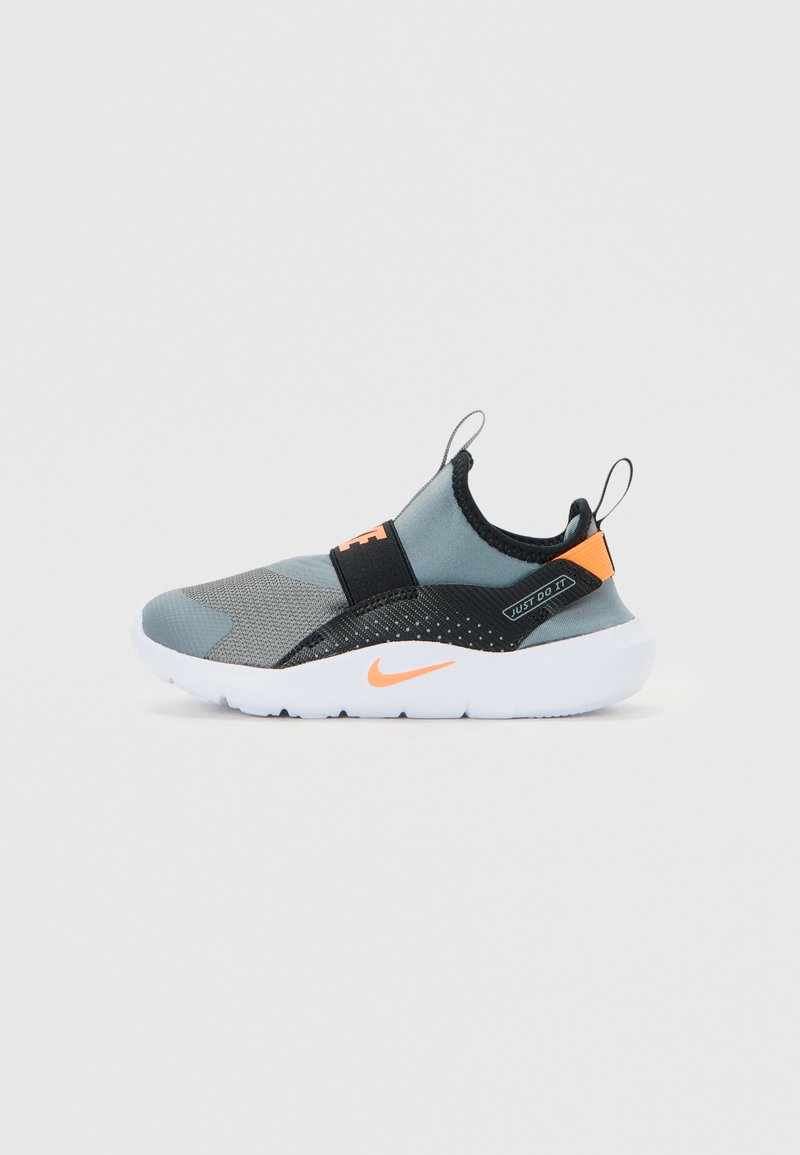 Sneaker grigio slip-on con il logo Nike arancione, fascia elastica nera, testo "Just Do It" e suola bianca su sfondo neutro.