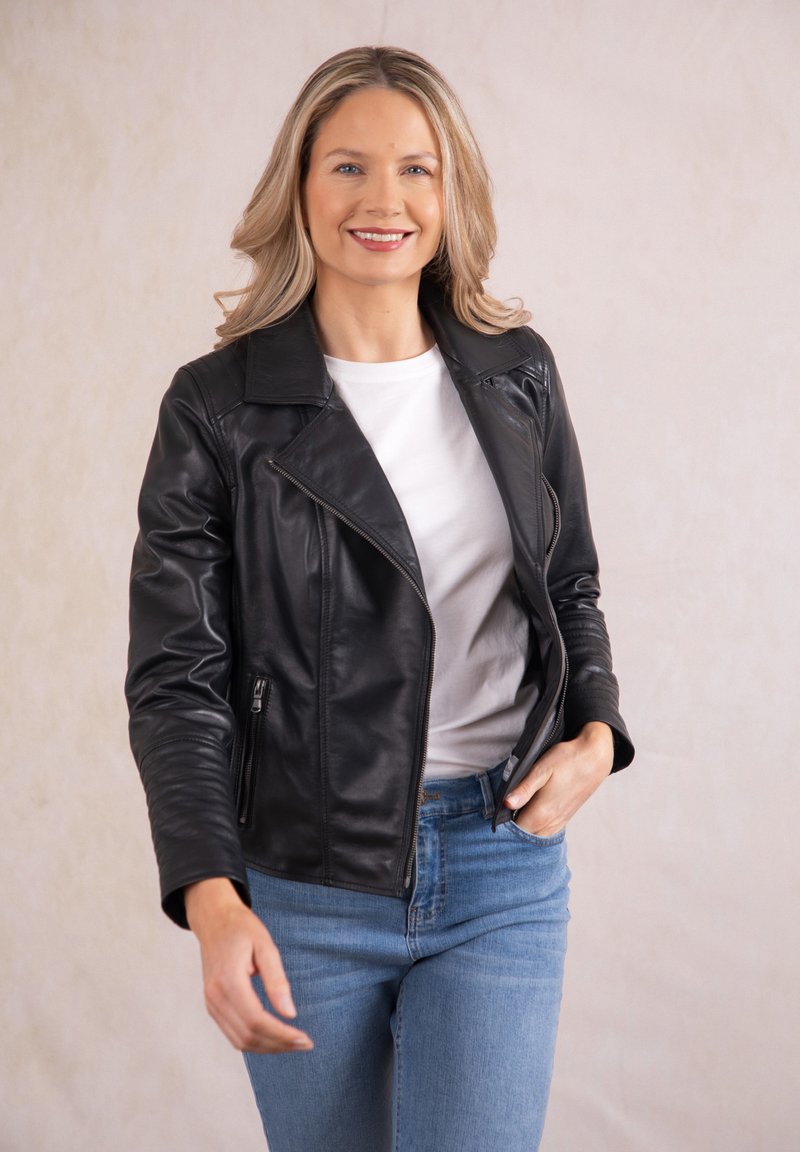 Black leather motorcycle jacket with a notched collar, zippered pockets, and fitted sleeves, worn over a white shirt and blue jeans.