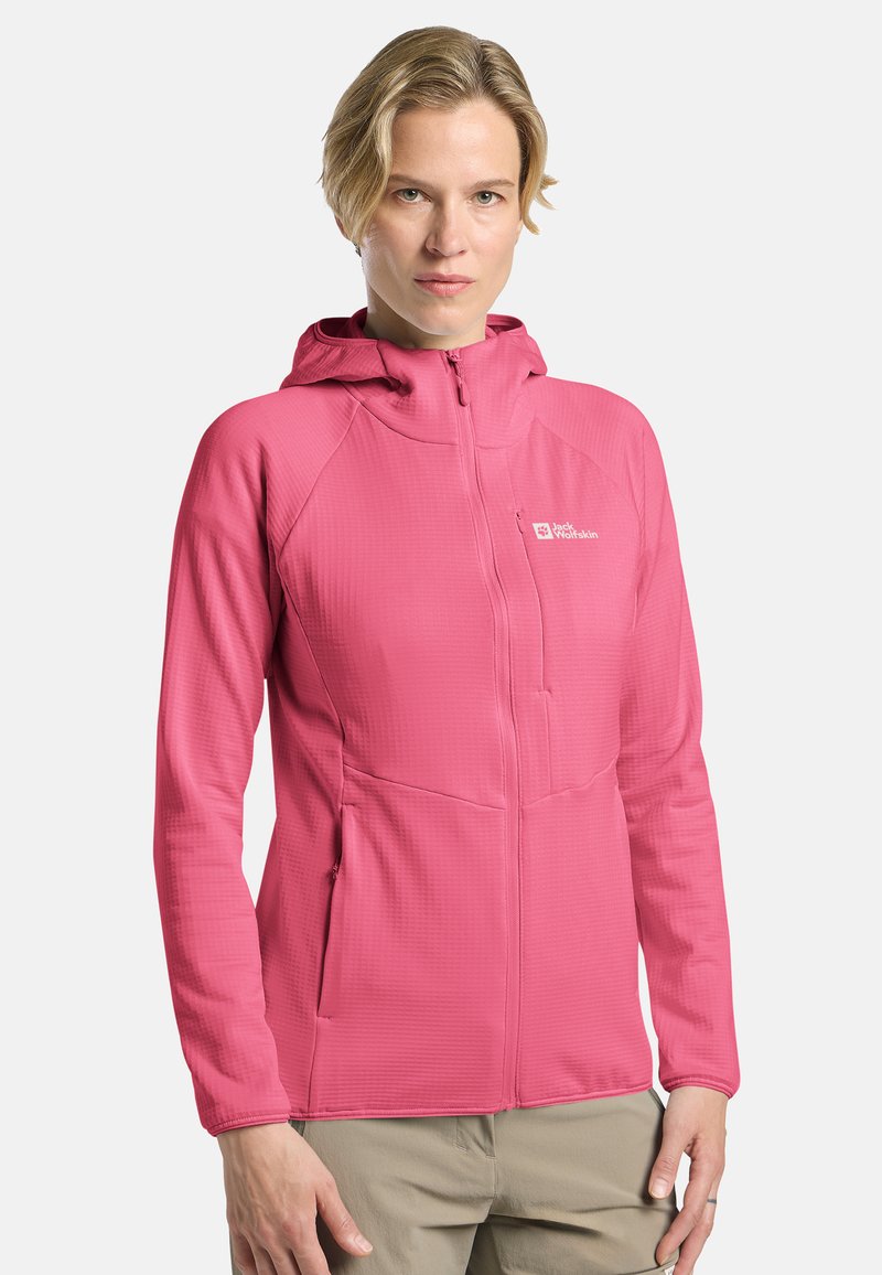 Veste à capuche rose en matériau texturé, dotée d'une fermeture éclair intégrale, de deux poches latérales et d'un logo sur le côté supérieur gauche de la poitrine.