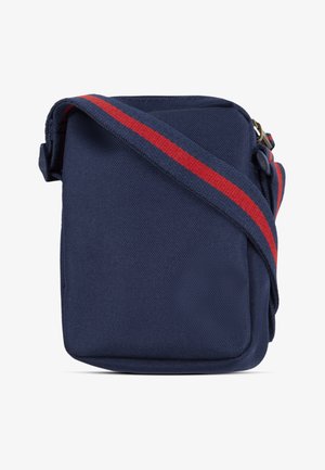 Geantă crossbody albastru închis din țesătură texturată, având o curea lată pentru umăr cu o dungă roșie centrală și o închidere cu fermoar în partea de sus.