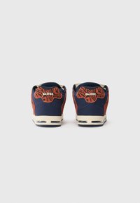 Pair of navy and orange sneakers with tiger stripes and "GLOBE" logo on heel, shown from the back against a plain background.