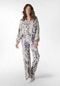Vloeiende blouse met paarse en groene patronen en bijpassende broek, gemaakt van een lichtgewicht stof, met een relaxte pasvorm en een zachte val.