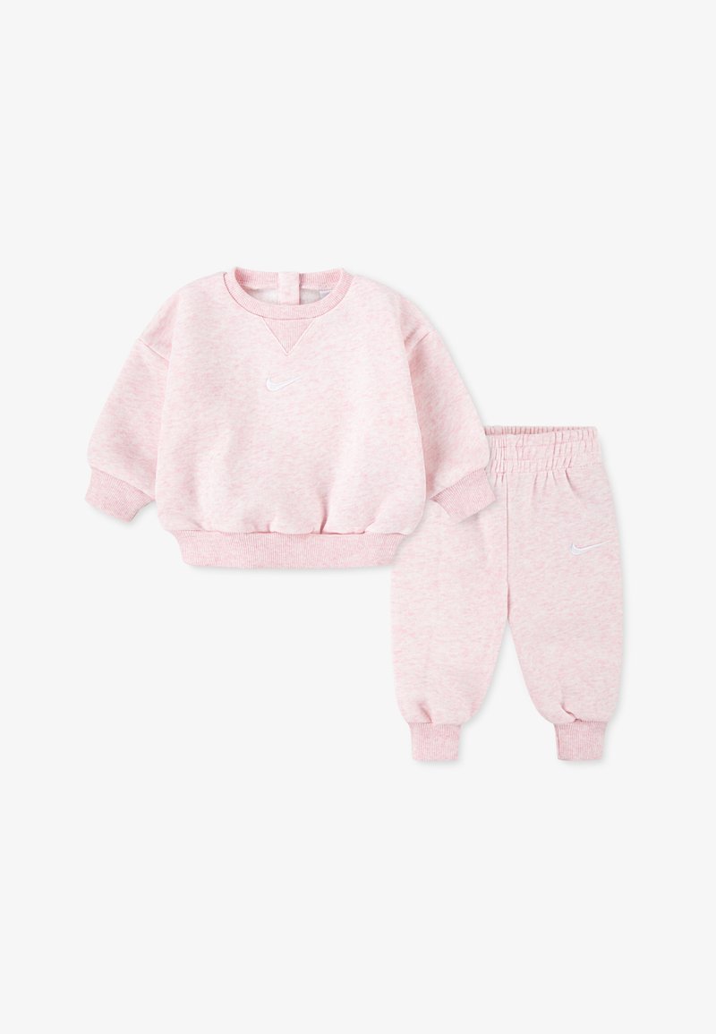 Conjunto de moletom e calças de algodão cor-de-rosa com decote redondo, punhos elásticos e um logótipo da Nike em branco no peito e na perna das calças.