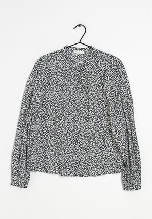 Langärmlige Bluse im schwarz-weißen gepunkteten Muster, leichtes Material, runder Ausschnitt und geraffte Ärmel mit elastischen Bündchen.