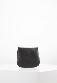 Svart läderpåse med texturerad yta, rundad form och dragkedja upptill. Har sömnadsdetaljer längs sömmarna.