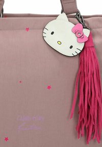Roze synthetische tote bag met een Hello Kitty gezicht label, een roze franje accent en verspreide sterpatronen. Geborduurde tekst leest "Hello Kitty Fritzi."