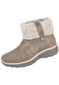 Bota hecha de ante topo con un puño de punto crema. Presenta una parte superior texturizada, una suela flexible y un pequeño detalle con correa lateral.