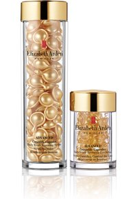 Deux contenants transparents contiennent des capsules de céramique dorées ; le plus grand est pour le sérum de restauration, tandis que le plus petit est pour le sérum pour les yeux.