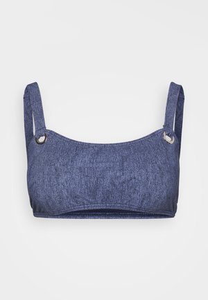 Denim blue bra top with a textured fabric, featuring adjustable shoulder straps and silver-tone hardware accents. Smooth, seamless design.