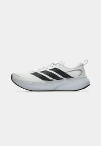 Λευκό αθλητικό παπούτσι με μαύρες ρίγες, παχύ μαξιλαροποιημένο πέλμα και θηλιά στο τακούνι, εμφανιζόμενο από αριστερή πλευρά σε λευκό φόντο.