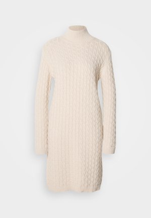 Strikket sweaterkjole i off-white med ribstrikket høj hals, lange ærmer og kabelstrik. Har en let afslappet pasform med en rund kant.