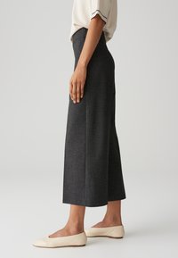 Grijze op maat gemaakte broeken met een cropped, wijduitlopend ontwerp, met een gladde textuur en een nette afwerking. Gecombineerd met lichte instap schoenen.