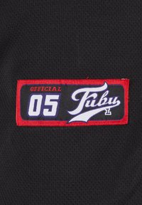 Țesătură din plasă neagră cu o mențiune rectangulare. Mențiunea are un bordou roșu, "OFFICIAL 05" în alb și violet și "Fubu" în litere stilizate albe.