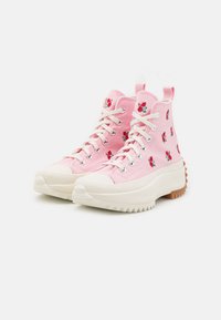 Vaaleanpunaiset korkeavartiset tennarit, jotka on valmistettu kankaasta ja joissa on kukka-embroidery, valkoinen kumipohja, pyöreä kärki ja teksturoitu pito-kuvio.