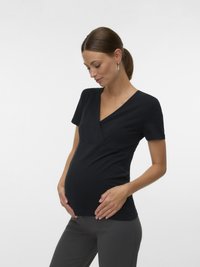 Μαύρο τοπ εγκυμοσύνης με V-λαιμόκοψη και κοντά μανίκια, με σχεδιασμό με στρώσεις στο μπροστινό μέρος. Μαλακό, ελαστικό ύφασμα κατάλληλο για διάφορα μεγέθη.