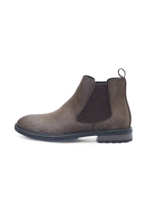 Botas de ante marrón hasta el tobillo con paneles laterales elásticos, punta redonda y tacón de goma bajo. Tiene una lengüeta en la parte posterior para facilitar su uso.
