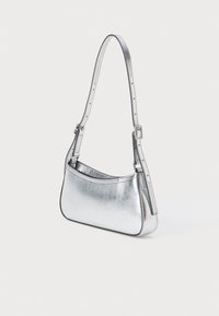 Hõbedane metallik õl 天天爱彩票app, millel on sile viimistlus, kaarjas kuju ja reguleeritav rihm, millel on pandlahendus.