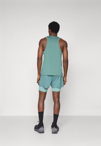 Mint green athletic tank top and shorts combination, with contrasting light mint trim. Textured fabric and fitted design, seen from the back.