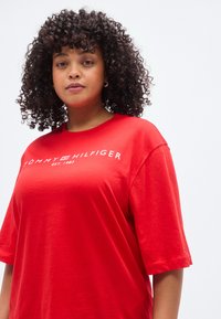 Κόκκινο βαμβακερό t-shirt με κοντά μανίκια, με λευκό λογότυπο "TOMMY HILFIGER" και το έτος ίδρυσης. Λειχή υφή με άνετη εφαρμογή.