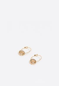 Pendientes de aro dorados con colgantes circulares adornados con brillantes de colores y caracteres grabados. Acabado de metal suave.