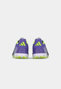Scarpe da atletica viola con accenti verdi, tomaia testurizzata e suola bianca. Design a strisce sulla parte posteriore con il logo a tre strisce sul tallone.
