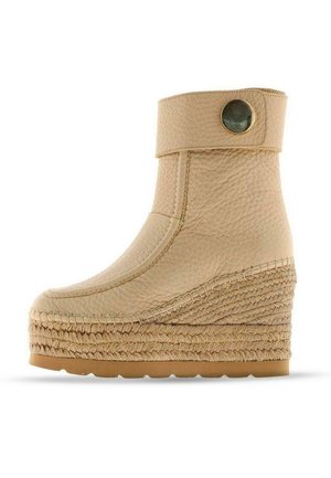 Stivale alla caviglia in pelle beige con una finitura testurizzata, dettaglio a bottone rotondo e suola in giuta intrecciata a forma di cuneo. Presenta un design con punta arrotondata.