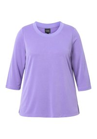 Lavendelfarbenes T-Shirt mit 3/4-Ärmeln, hergestellt aus weicher, glatter Stoffqualität. Rundhalsausschnitt mit Seitenschlitzen am Saum für mehr Bewegungsfreiheit.