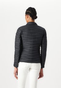 Casaco puffer preto com padrão acolchoado horizontal e design em painéis. Apresenta um colarinho, mangas compridas e textura de tecido sintético.