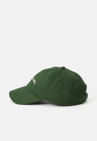 Mørkegrønn baseballcaps plassert på en hvit bakgrunn, med et enkelt design og brodert logo på forsiden.