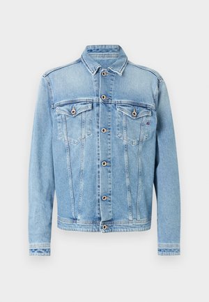 Hele sinine teksatagi, millel on terav krae, ees nööpidega sulgur ja kaks rinnataskut, millel on tikitud detailid ja kontrastsed õmblused.