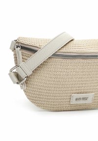 Borsa intrecciata beige con una finitura testurizzata, dotata di una tracolla in pelle liscia e chiusura con cerniera. Dettaglio in metallo argentato vicino alla cerniera.