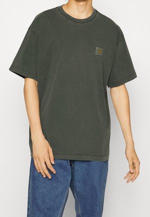 T-shirt oversize vert foncé en coton avec manches courtes, col rond et une petite étiquette de marque sur le côté gauche de la poitrine. Coupe ample.