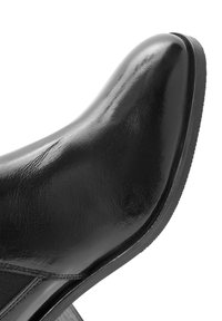 Scarpa in vernice nera con punta affusolata, design elegante e tacco basso. Caratterizzata da una texture liscia e dettagli di cucitura sottile.